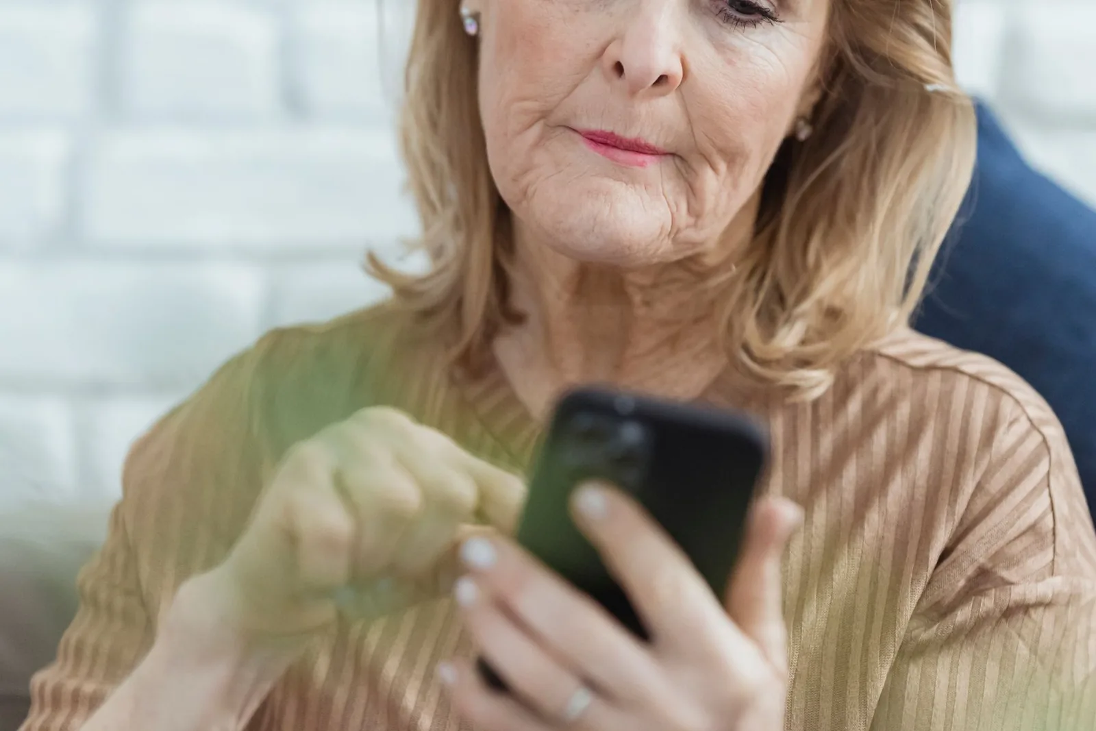 Vrouw leest thuis op haar telefoon een bericht over haar plek op de wachtlijst